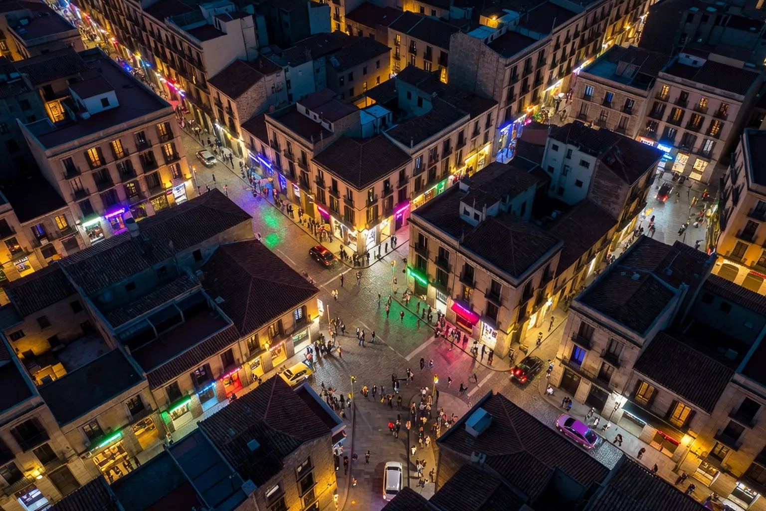 Vue aérienne du Raval de Barcelone la nuit, rues animées et lumières colorées
